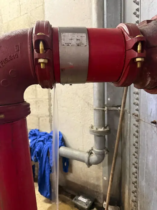 Fuite en jet sur un raccord de réseau sprinkler corrodé