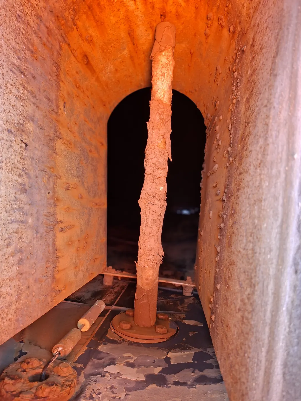 Chambre non protégée à l'intérieur d'une cuve source : acier nu tuberculé et colonne verticale qui s'exfolie en écailles